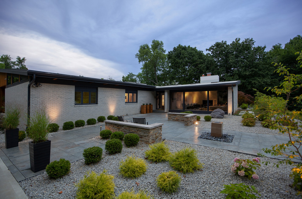 Inspiration for a mid-sized mid-century modern white one-story brick house exterior remodel in Indianapolis with a shed roof