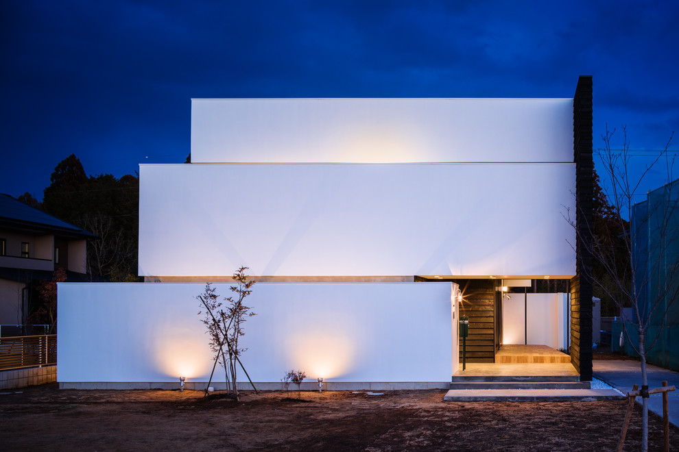 Cette image montre une façade de maison blanche design à deux étages et plus avec un toit plat.