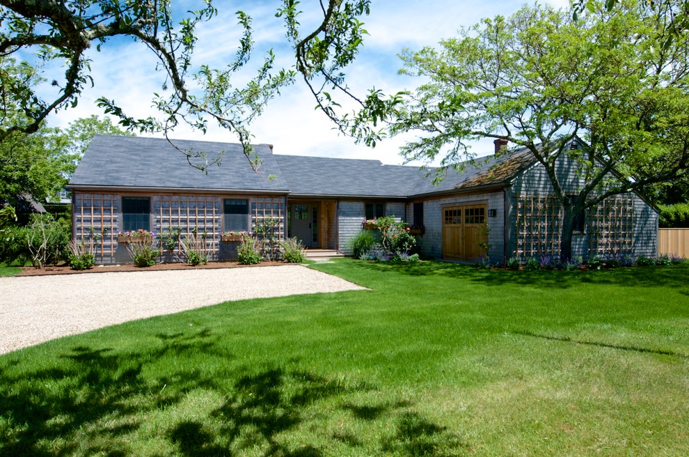 Imagen de fachada de casa contemporánea grande de una planta con revestimiento de madera, tejado a dos aguas y tejado de teja de madera