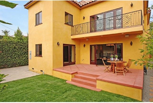 Стильный дизайн: двухэтажный, желтый дом среднего размера в средиземноморском стиле с облицовкой из цементной штукатурки и двускатной крышей - последний тренд