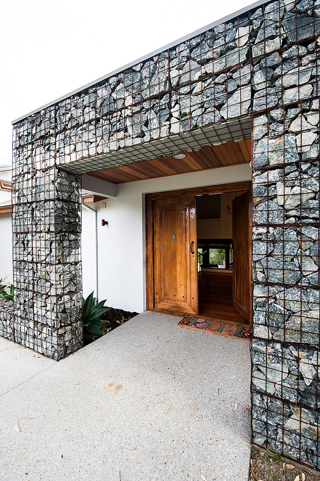 Idée de décoration pour une façade de maison design en pierre de taille moyenne.