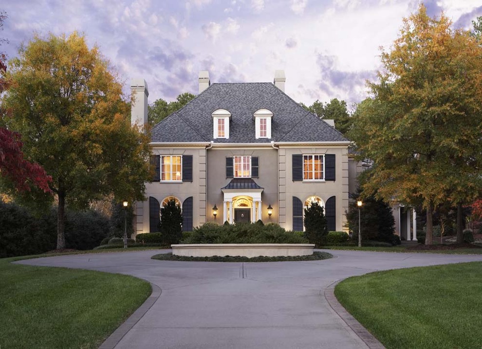 Стильный дизайн: большой, двухэтажный, бежевый дом в классическом стиле с облицовкой из цементной штукатурки - последний тренд