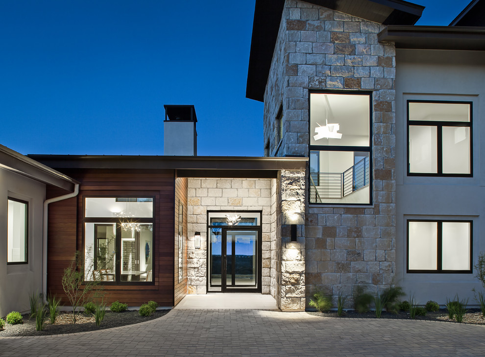 Großes, Zweistöckiges Modernes Einfamilienhaus mit Mix-Fassade, beiger Fassadenfarbe, Pultdach und Blechdach in Austin