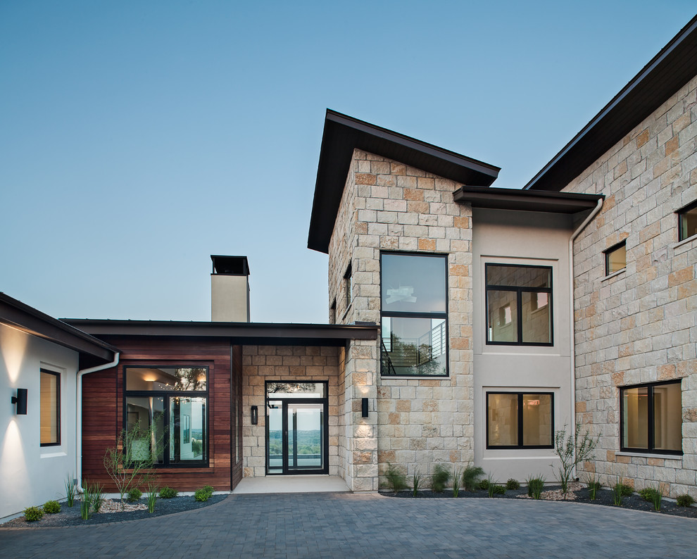 Aménagement d'une grande façade de maison beige contemporaine à un étage avec un revêtement mixte, un toit en appentis et un toit en métal.