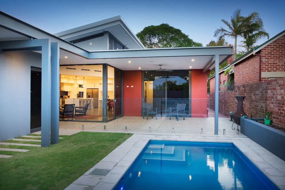Réalisation d'une façade de maison rouge design en panneau de béton fibré de taille moyenne et de plain-pied avec un toit plat.