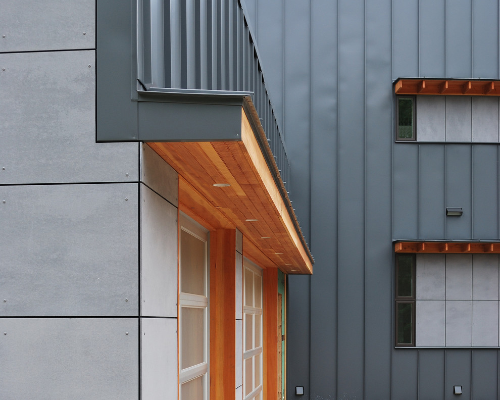 Modelo de fachada gris minimalista grande de tres plantas con revestimientos combinados y tejado de un solo tendido