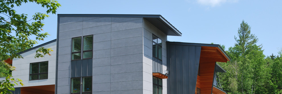 Diseño de fachada gris actual grande de tres plantas con revestimientos combinados y tejado de un solo tendido