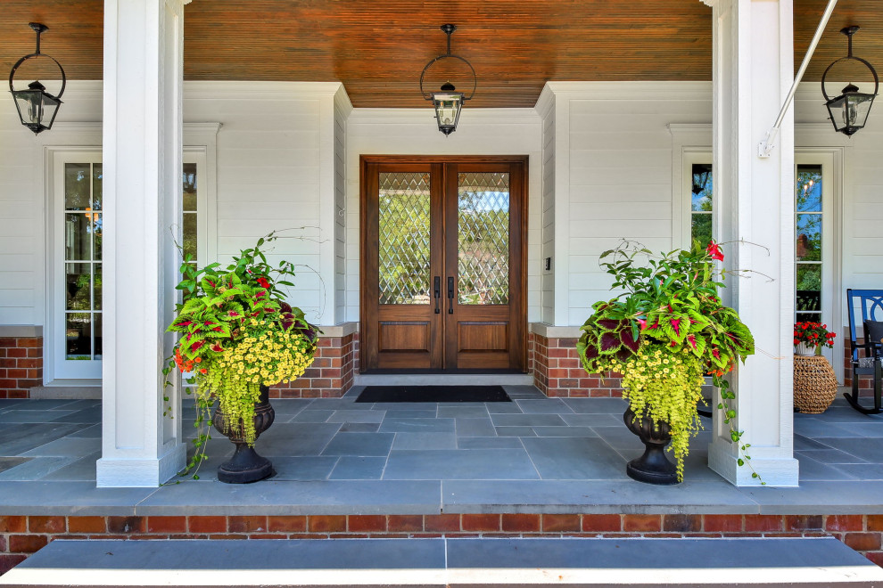 Imagen de fachada de casa blanca tradicional renovada grande de dos plantas con revestimientos combinados