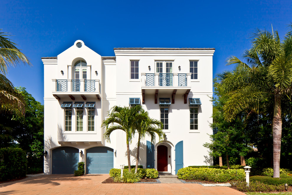 Diseño de fachada beige exótica de tres plantas con revestimiento de estuco y tejado plano