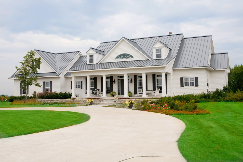 Cette image montre une façade de maison blanche rustique à un étage avec un revêtement en vinyle et un toit à deux pans.