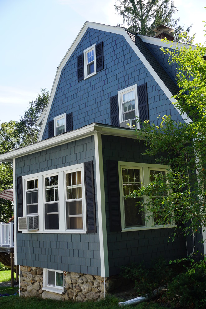 Medium sized and blue classic detached house in Boston with three floors, concrete fibreboard cladding, a mansard roof and a shingle roof.