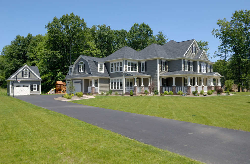 Diseño de fachada gris de estilo de casa de campo grande de tres plantas con revestimientos combinados