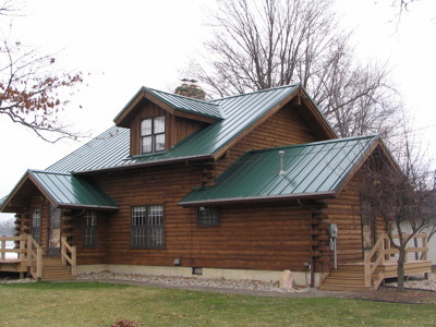 Foto della facciata di una casa marrone rustica a due piani con rivestimento in legno e tetto a capanna