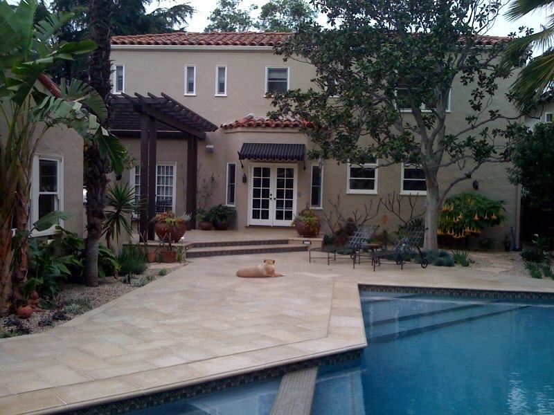 Large elegant beige two-story stucco exterior home photo in Los Angeles with a tile roof