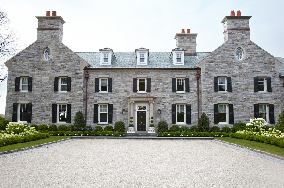 Cette photo montre une très grande façade de maison grise chic en pierre à deux étages et plus avec un toit à deux pans.