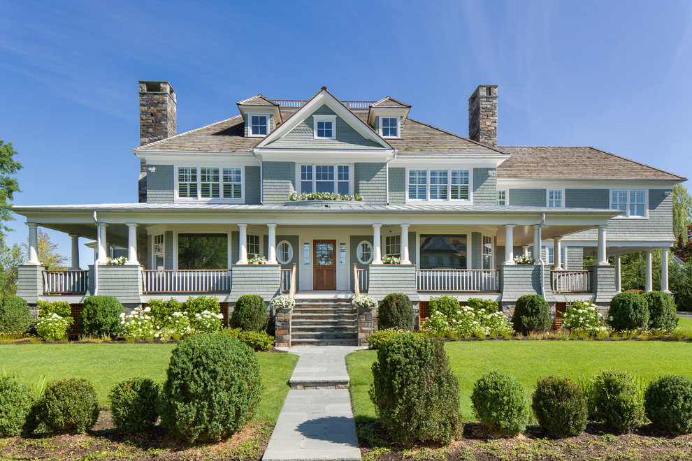 Diseño de fachada de casa gris costera grande de dos plantas con revestimiento de madera, tejado a cuatro aguas y tejado de teja de madera