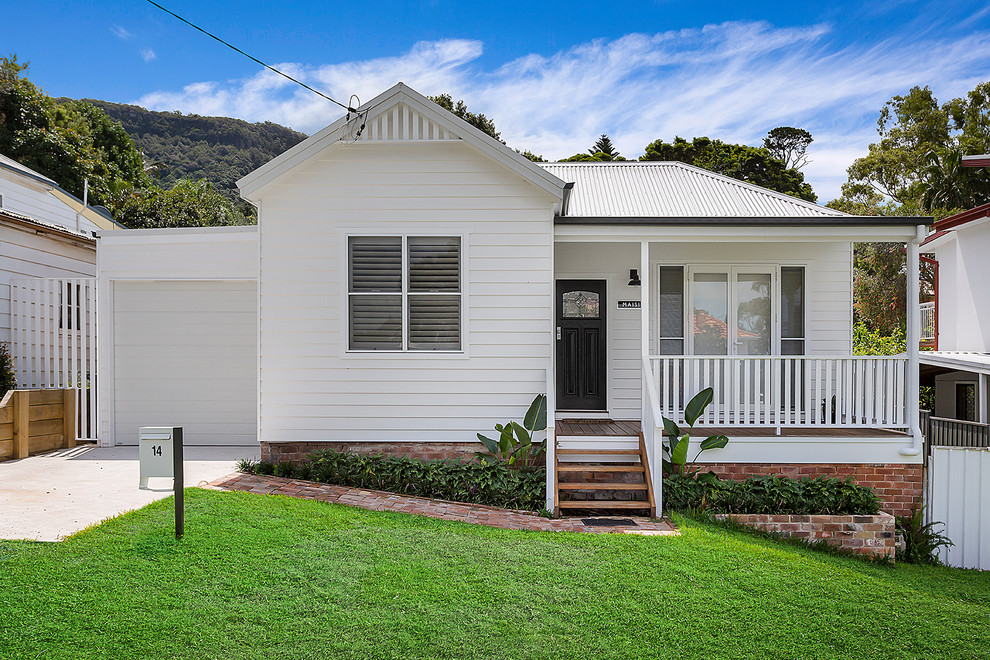 Beach style white one-story house exterior photo in Wollongong with a metal roof and a hip roof