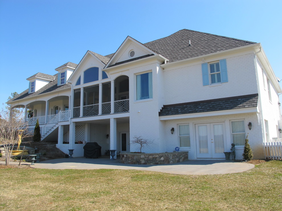 Example of a mid-sized classic white two-story brick exterior home design in Detroit with a clipped gable roof