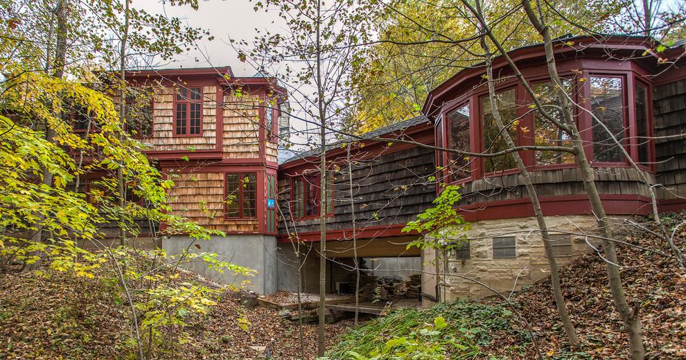 Immagine della facciata di una casa piccola marrone rustica a due piani con rivestimento in legno e tetto a padiglione