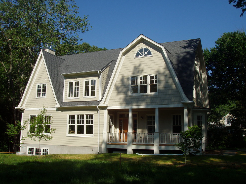 Esempio della facciata di una casa beige classica a tre piani di medie dimensioni con rivestimento con lastre in cemento e tetto a mansarda