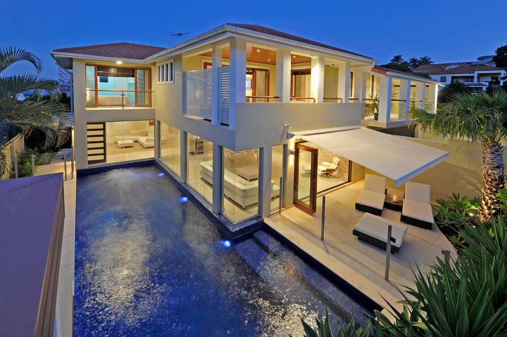 Стильный дизайн: двухэтажный, бежевый дом среднего размера в стиле неоклассика (современная классика) с облицовкой из бетона - последний тренд