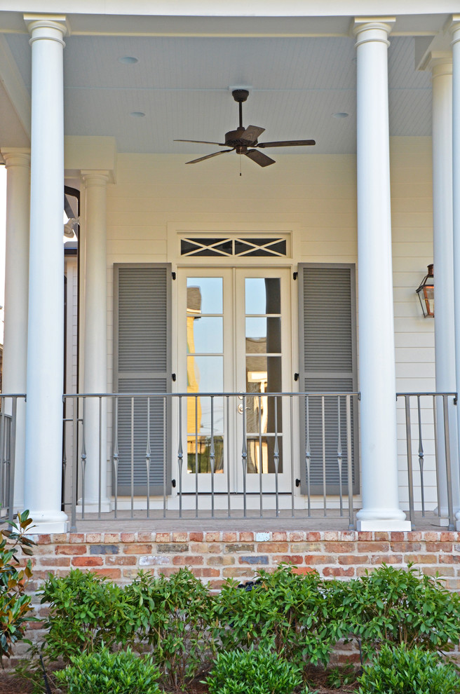 Mittelgroßes, Zweistöckiges Klassisches Haus mit Faserzement-Fassade und weißer Fassadenfarbe in New Orleans