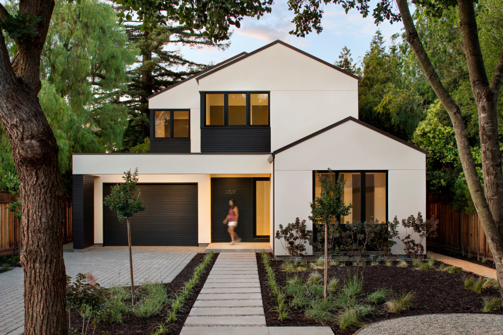 Exemple d'une façade de maison beige tendance de taille moyenne et à un étage avec un toit à deux pans et un toit en métal.