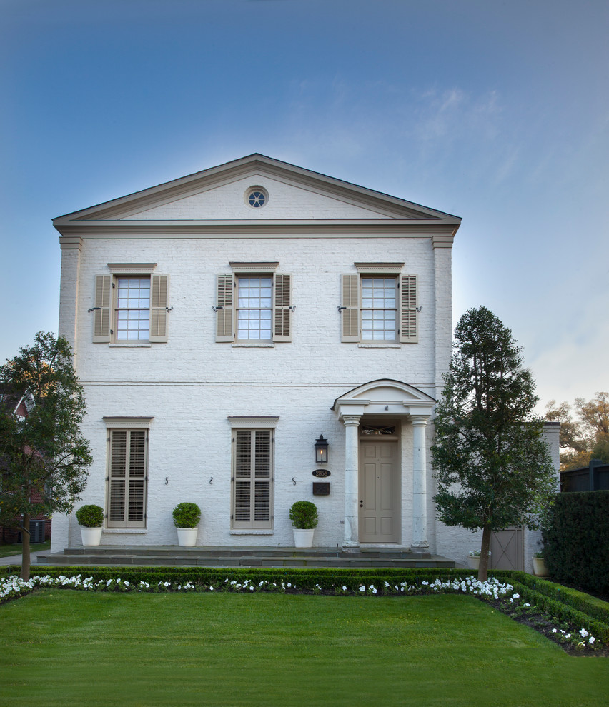 Foto della facciata di una casa bianca classica a due piani con rivestimento in mattoni