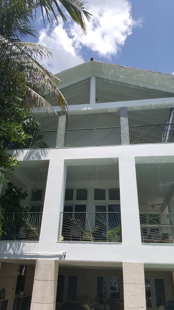 Diseño de fachada blanca contemporánea grande de tres plantas con revestimiento de estuco y tejado a dos aguas