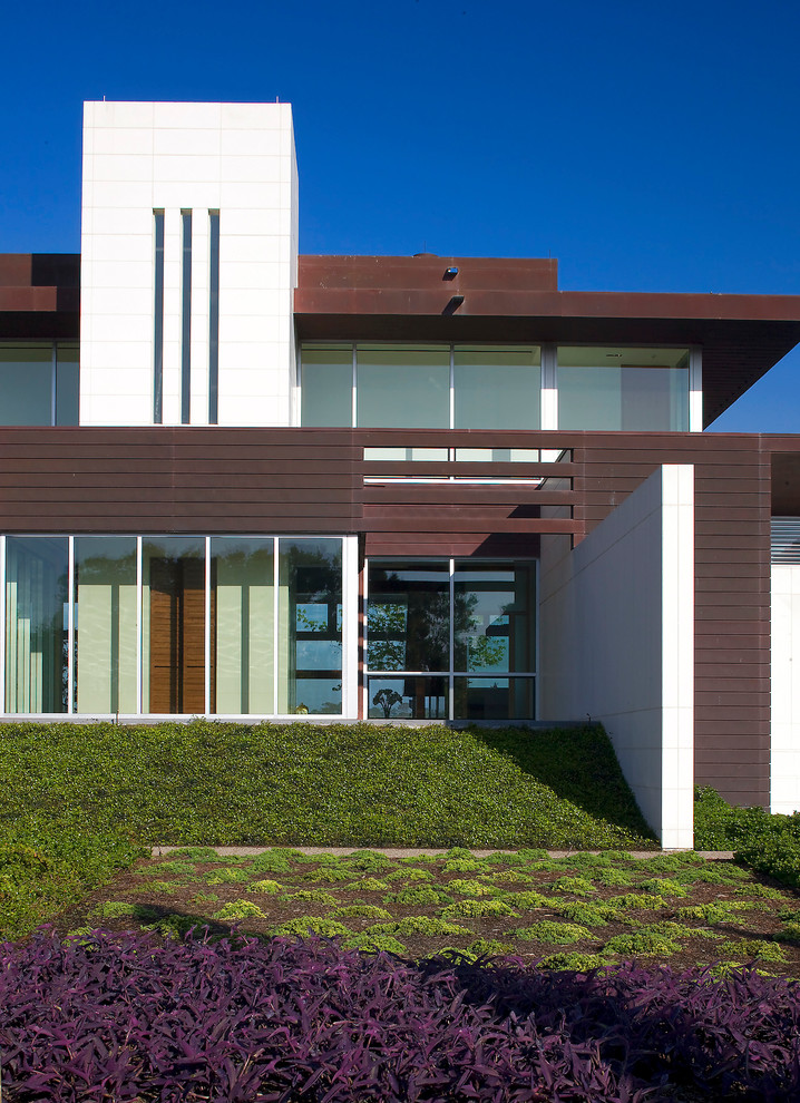 This is an example of a contemporary house exterior in Houston with stone cladding and a metal roof.