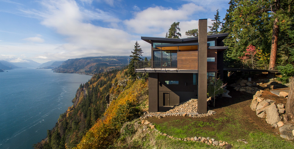 Стильный дизайн: двухэтажный, коричневый дом в стиле модернизм с комбинированной облицовкой и плоской крышей - последний тренд
