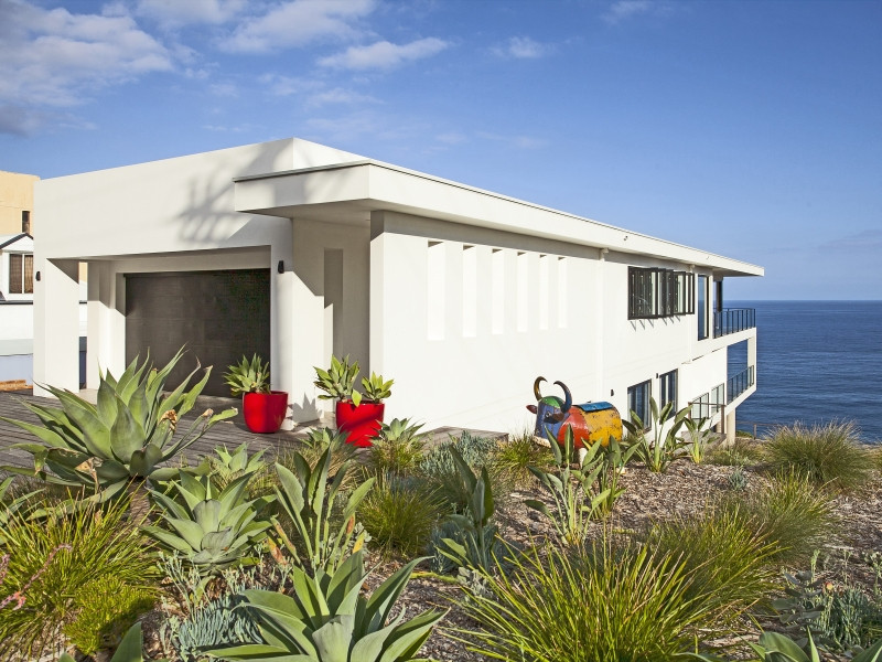 Immagine della villa bianca eclettica a due piani di medie dimensioni con rivestimento in mattoni, tetto piano e copertura in metallo o lamiera