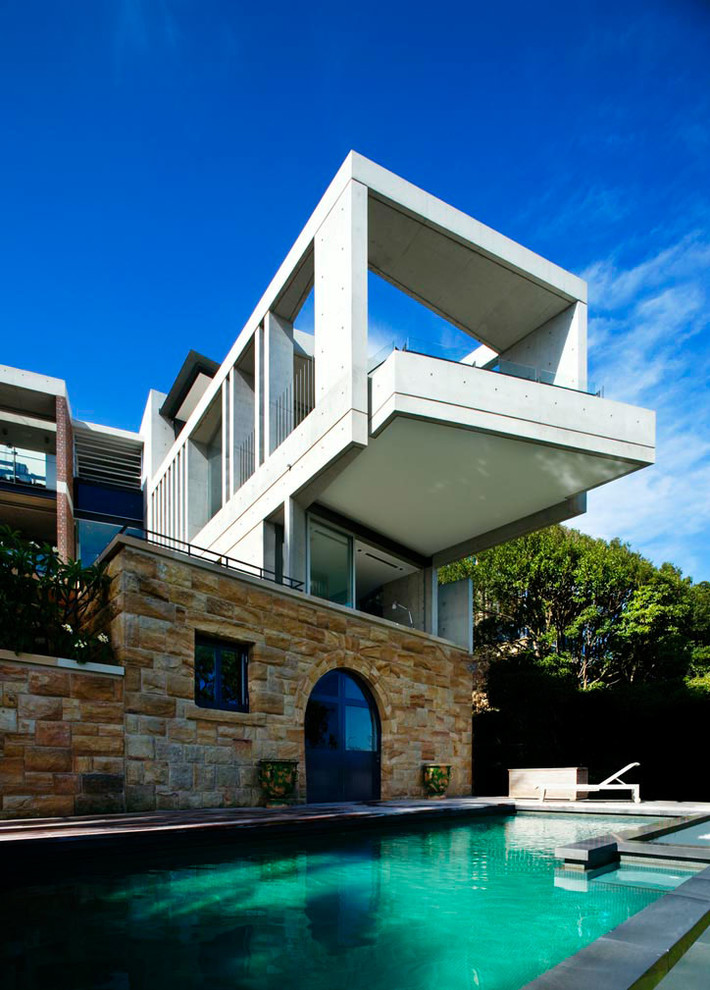 На фото: большой, трехэтажный дом в стиле модернизм с облицовкой из бетона