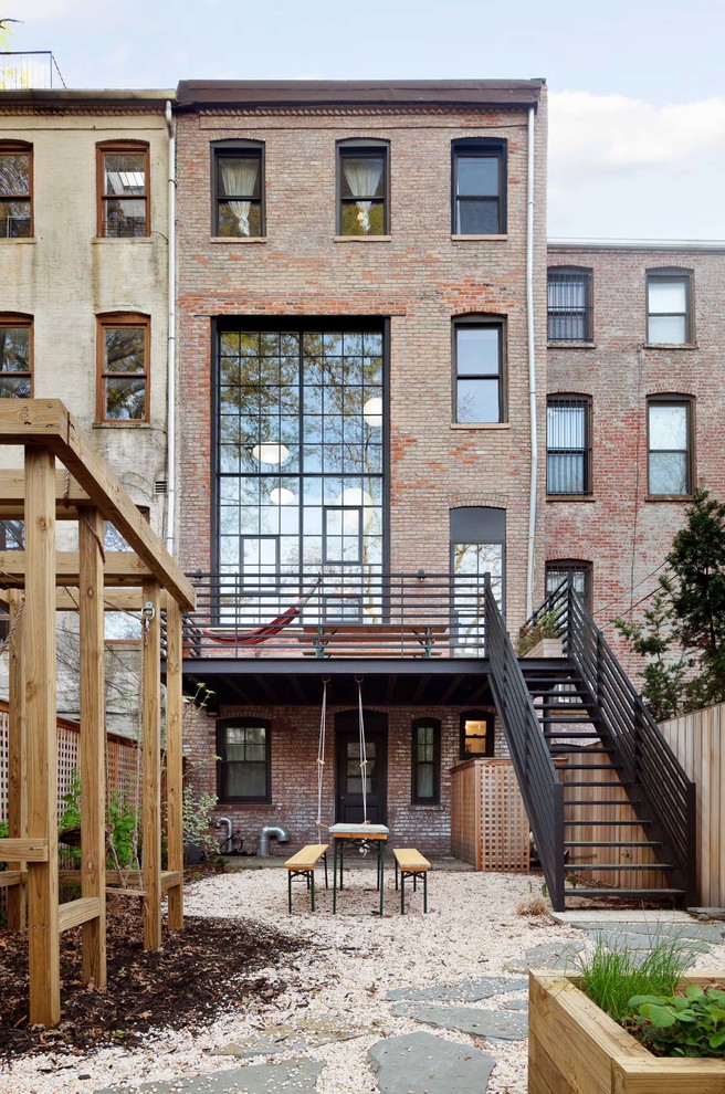 Immagine della facciata di una casa a schiera grande marrone industriale a tre piani