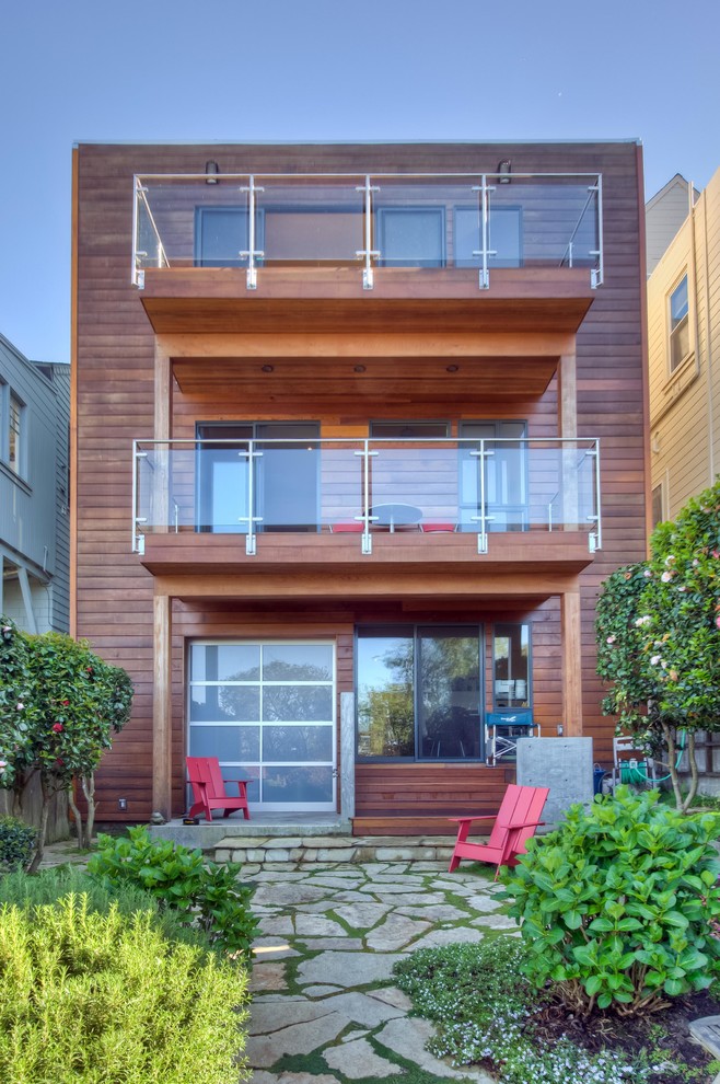 Ejemplo de fachada de casa minimalista de tres plantas con revestimiento de madera y tejado plano