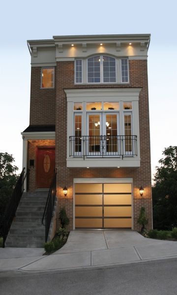 Imagen de fachada de casa marrón clásica de tamaño medio de tres plantas con revestimiento de ladrillo y tejado plano