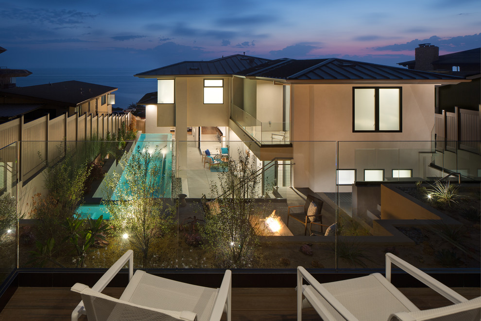 Стильный дизайн: большой, трехэтажный, бежевый частный загородный дом в стиле модернизм с облицовкой из цементной штукатурки, вальмовой крышей и металлической крышей - последний тренд