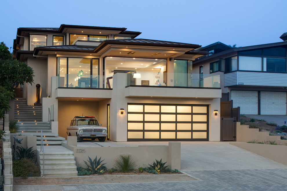 Inspiration pour une grande façade de maison beige minimaliste en stuc à deux étages et plus avec un toit à quatre pans et un toit en métal.