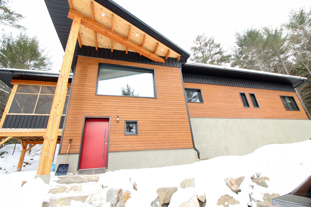 Cette image montre une très grande façade de maison multicolore craftsman en bois à un étage avec un toit plat.