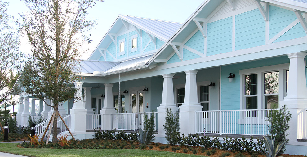 Esempio della facciata di una casa blu tropicale a un piano con rivestimenti misti