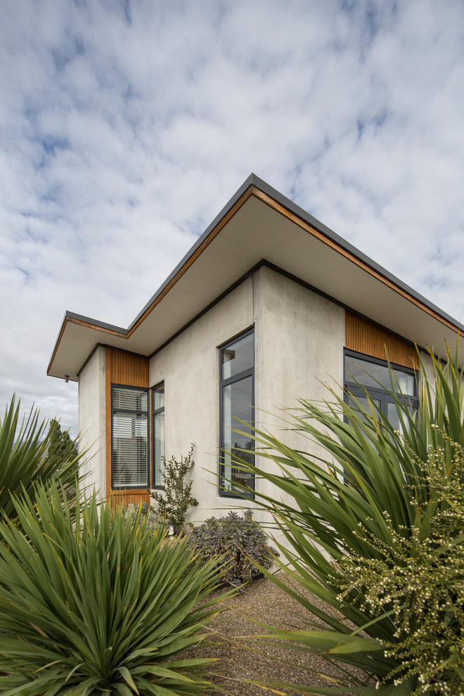 Источник вдохновения для домашнего уюта: маленький, одноэтажный, серый частный загородный дом в стиле модернизм с облицовкой из бетона, плоской крышей и металлической крышей для на участке и в саду