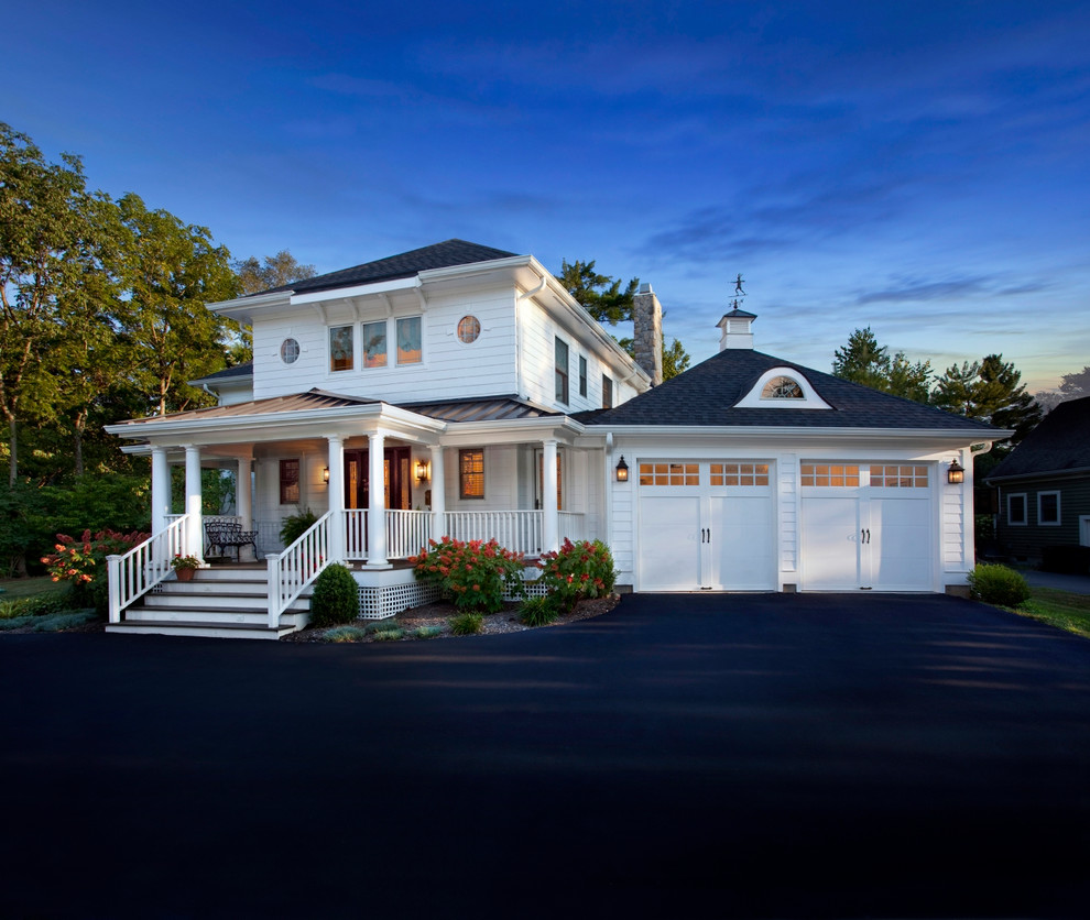Aménagement d'une façade de maison blanche campagne de taille moyenne et à un étage avec un revêtement en vinyle et un toit à deux pans.