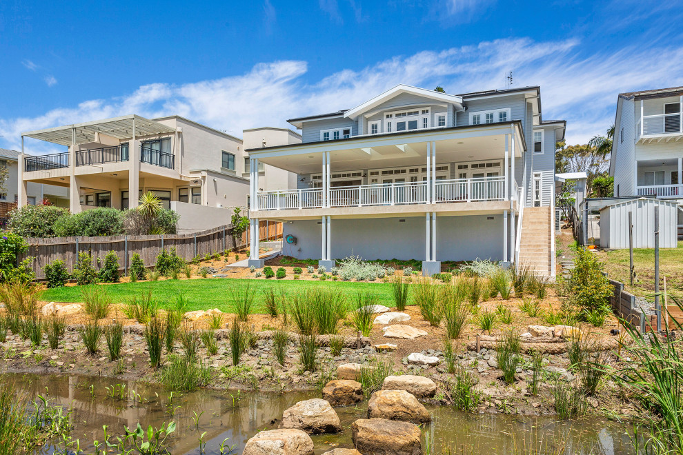Example of a large beach style multicolored two-story exterior home design in Wollongong with a tile roof
