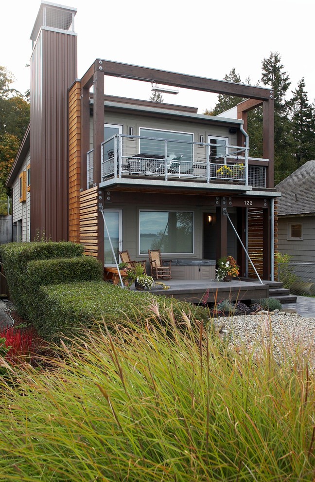 Réalisation d'une façade de maison multicolore minimaliste en bois de taille moyenne et à un étage avec un toit en appentis et un toit en métal.
