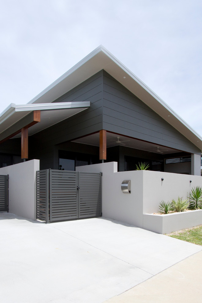 Ejemplo de fachada de casa gris actual de tamaño medio de una planta con tejado de un solo tendido, tejado de metal y revestimientos combinados