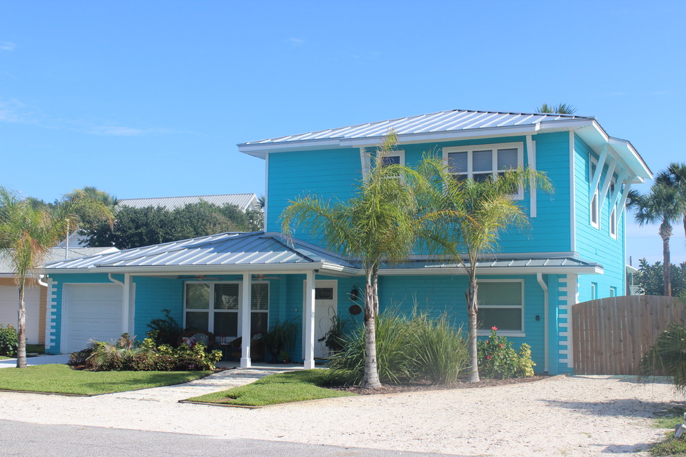 Imagen de fachada azul costera de tamaño medio de dos plantas con revestimientos combinados y tejado a cuatro aguas