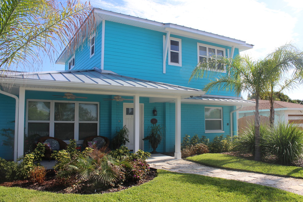 Idée de décoration pour une façade de maison bleue marine de taille moyenne et à un étage avec un revêtement mixte, un toit à quatre pans et un toit en métal.