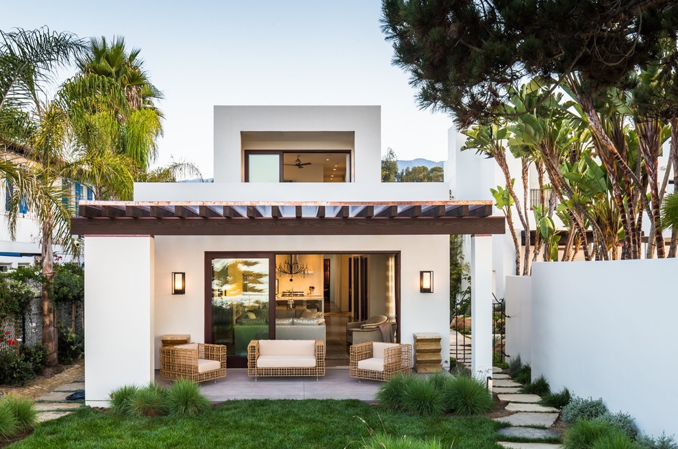 Example of a trendy white two-story stucco flat roof design in Santa Barbara
