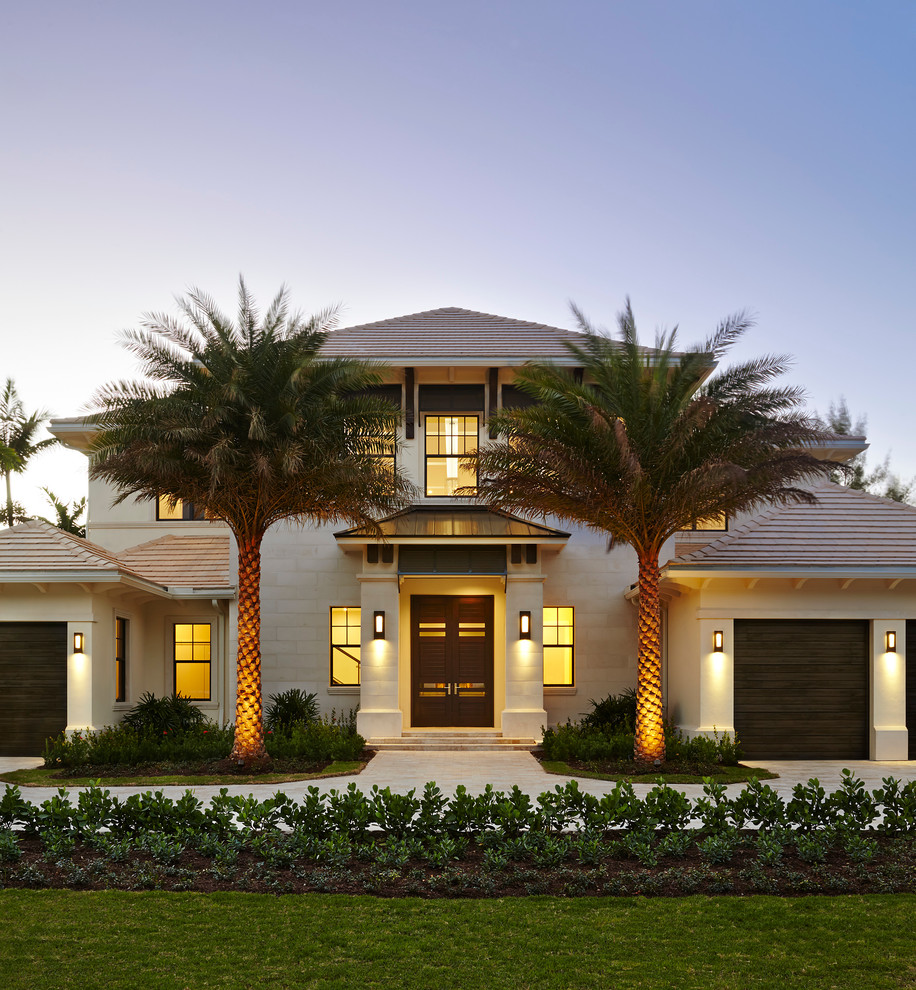 Large tropical white two-story stucco exterior home idea in Miami with a hip roof