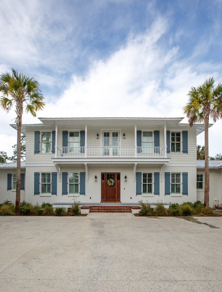 This is an example of a large and beige beach style two floor detached house in Jacksonville with vinyl cladding, a hip roof and a metal roof.